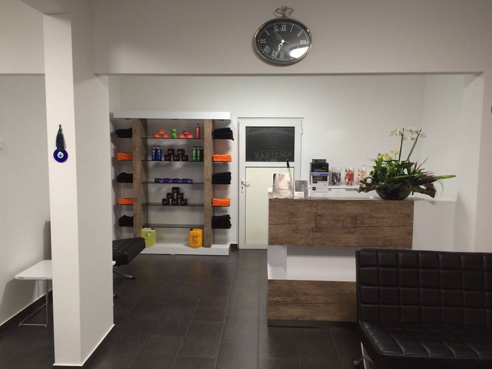 De ontvangstbalie met een plant, schappen vol producten en zwarte leren stoelen